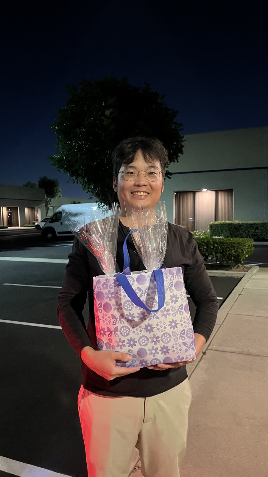 Hong Jik Lee holding a thank-you gift after visiting Beyond Cosmo